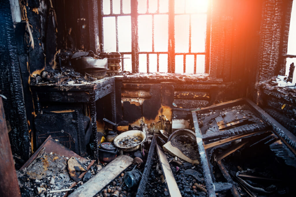 Burnt house interior. Burned kitchen, remains of furniture in black soot.