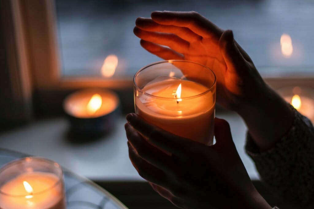 Woman Holding Glass Candle | Housefire Risks during Holidays